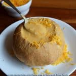 cheese soup in bread bowl on white plate