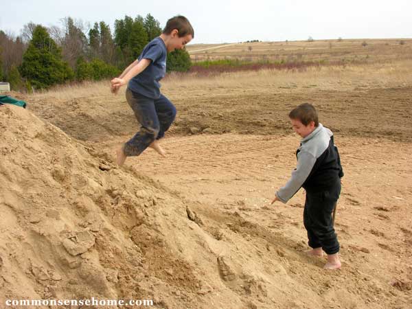 boys playing in sand pile