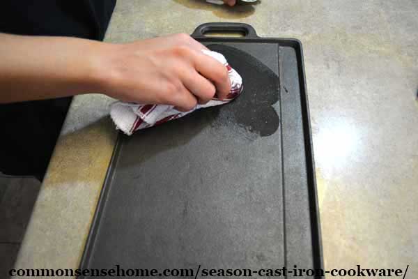 applying oil to season a cast iron griddle