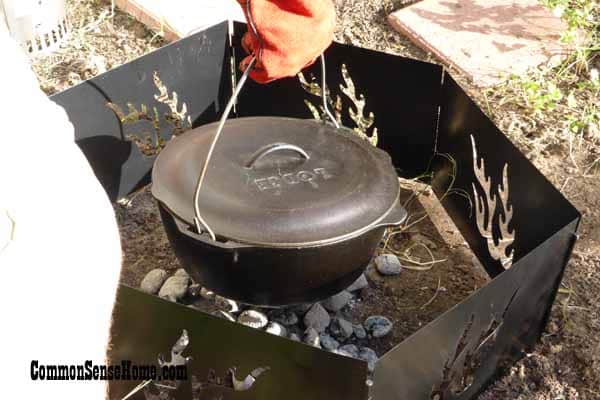 Placing a Dutch oven on the coals for cooking