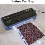 small, black FoodSaver Vacuum Sealer machine sealing a package of dried cranberries
