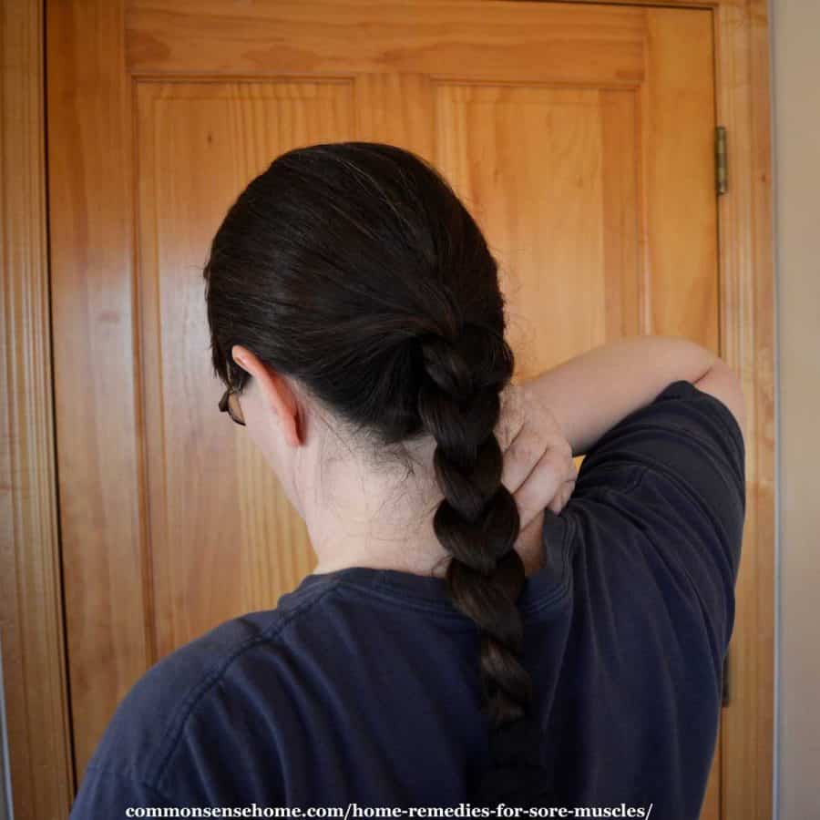 woman rubbing sore muscles in neck