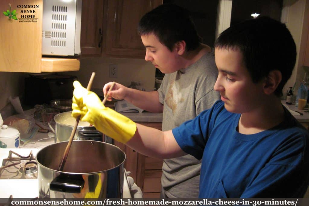 Two boys making homemade mozzarella cheese