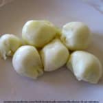Homemade mozzarella balls sitting on a white plate