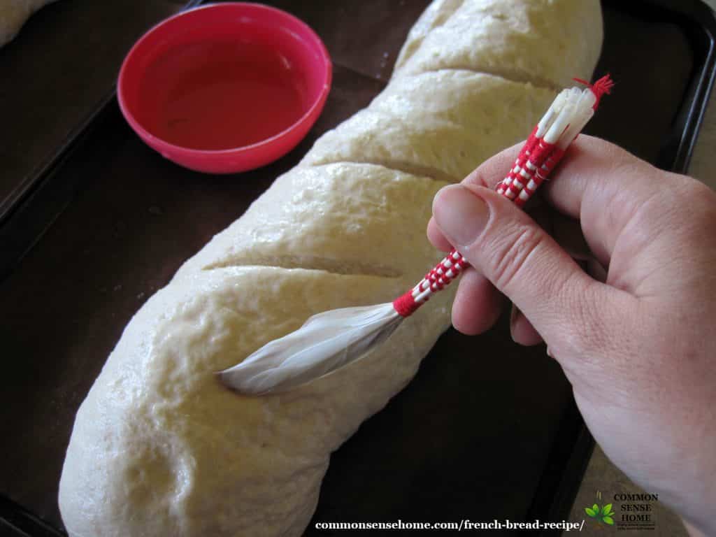 brushing on the salt water glaze for crusty French bread