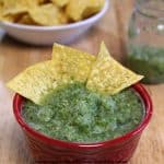 tomatillo salsa (salsa verde) with chips in a red bowl