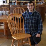 young man with wooden kitchen chair