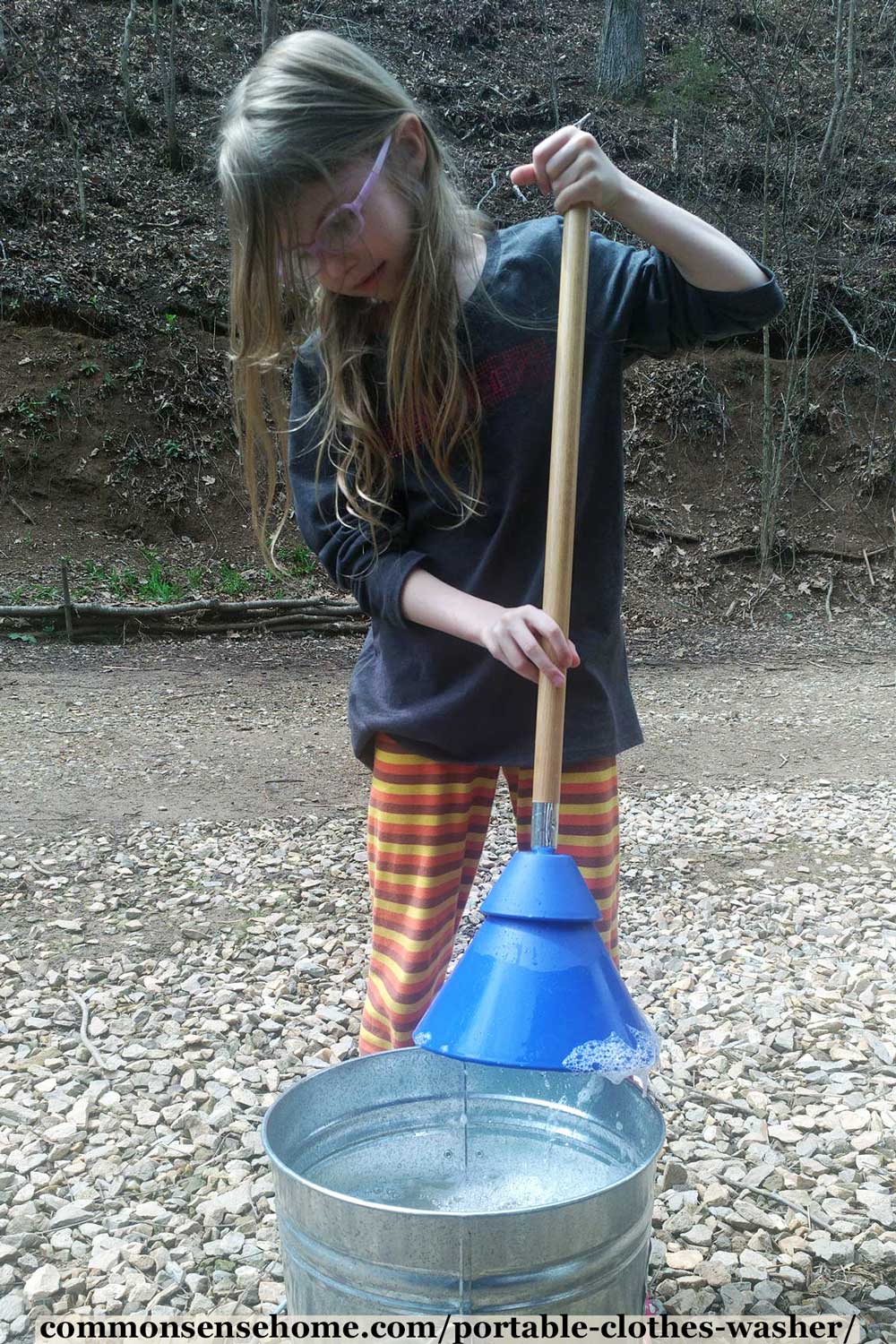 girl with plunger style washer cleaning clothes