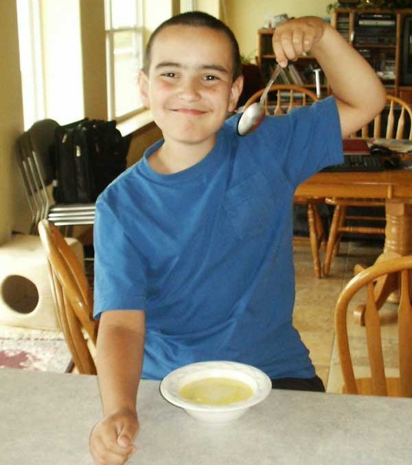happy boy eating homemade soup