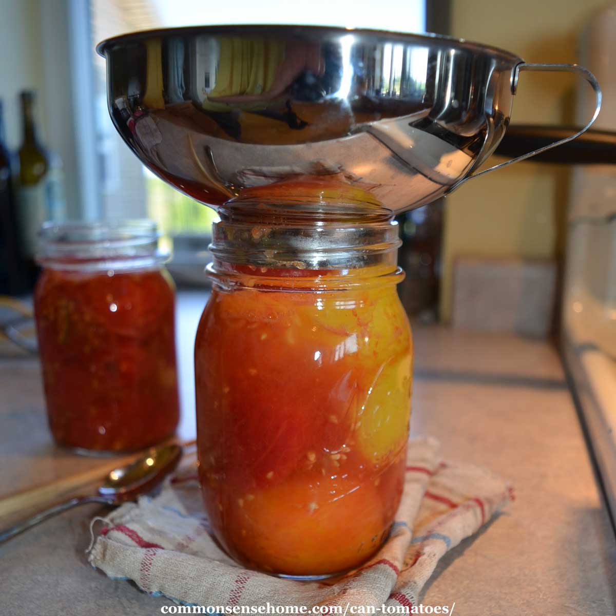 filling mason jar with tomatoes