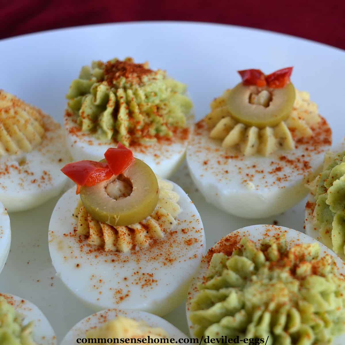 classic deviled eggs and avocado deviled eggs on a white plate