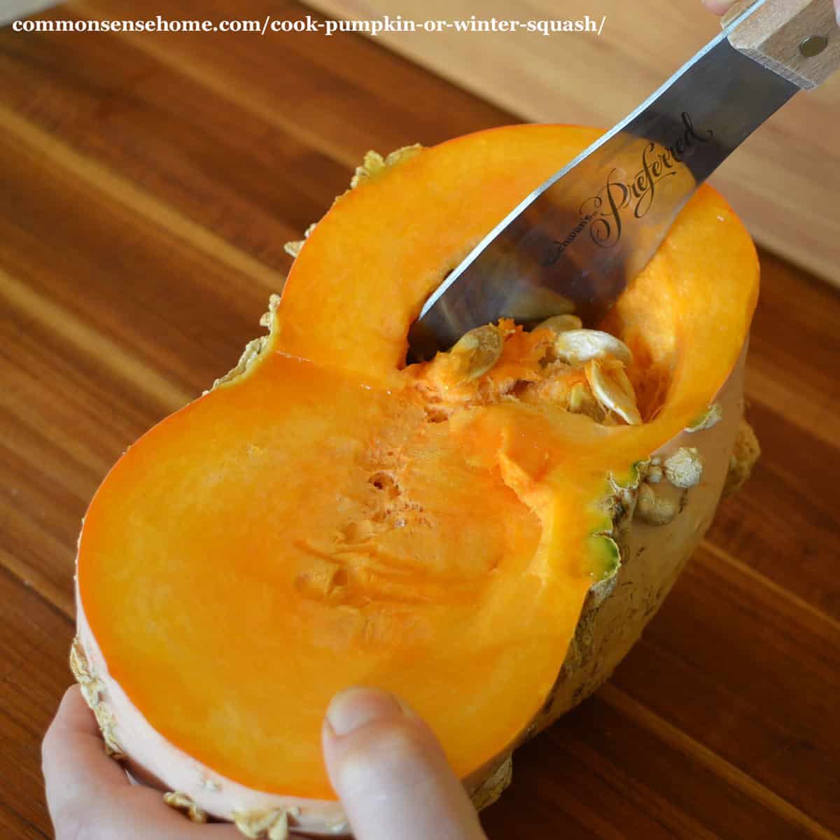 scooping seeds out of raw pumpkin half