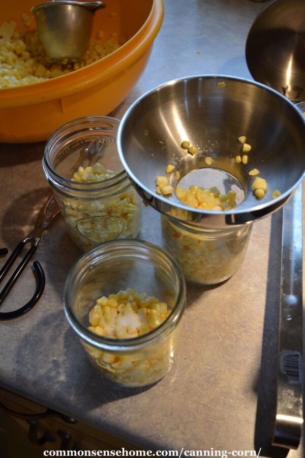 filling jars with sweet corn