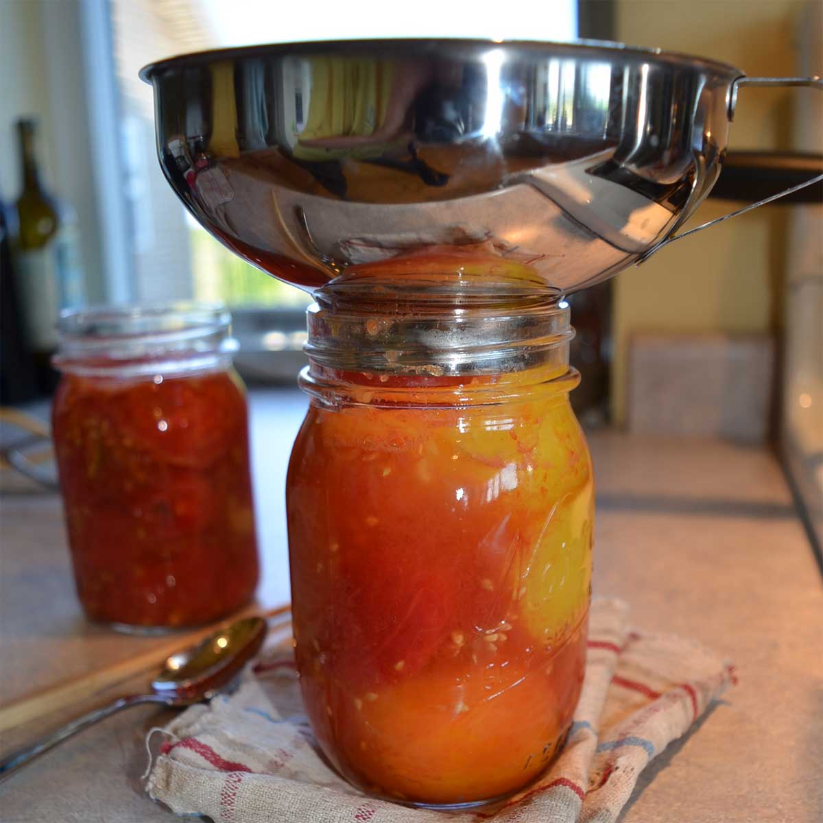 filling jars with tomatoes