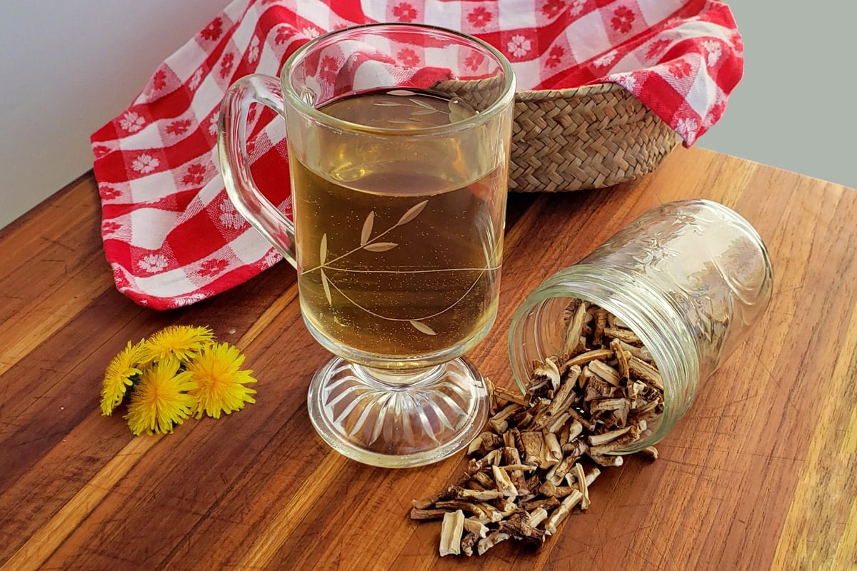 glass of dandelion root tea with dried roots