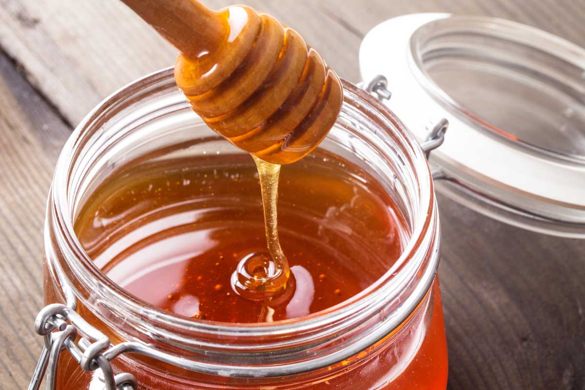 jar of honey with honey dipper