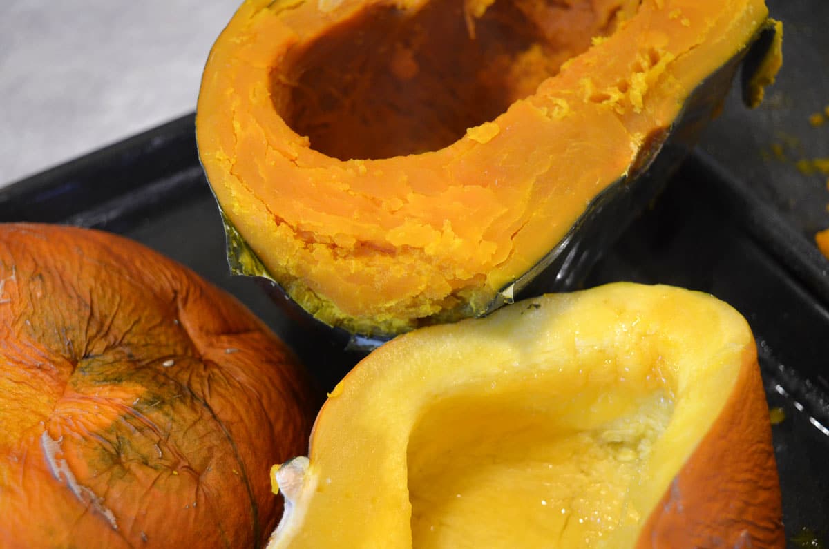 cooked pumpkin and winter squash halves on pan