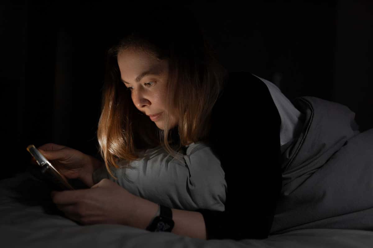scrolling on phone in bed