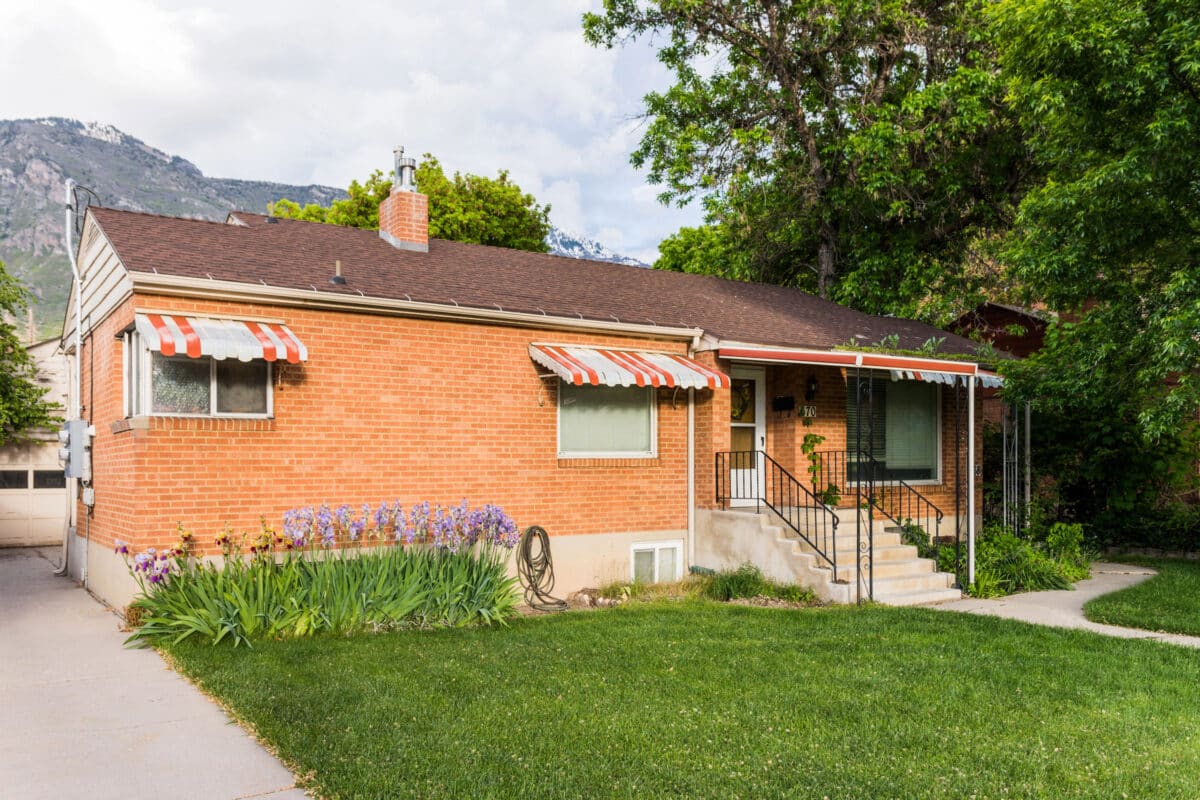brick house with window awnings to keep the house cool in summer
